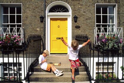 Dos niños frente a una de las típicas puertas coloristas de las casas de estilo georgiano en Dublín.