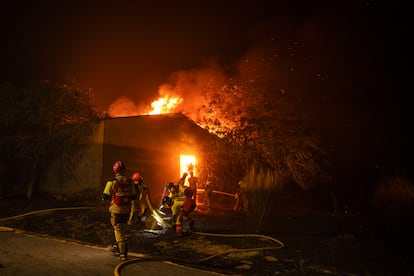 Los bomberos tratan de sofocar un incendio en una construcción en la localidad de A Caridade, en el municipio de Monterrei (Ourense), este jueves.