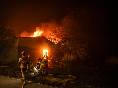 Los bomberos tratan de sofocar un incendio en una construcción en la localidad de A Caridade, en el municipio de Monterrei (Ourense), este jueves.