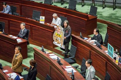 Leung Kwok-hung, conocido como "pelo largo", muestra una pancarta de un mono que recuerda al presidente ejecutivo Leung Chun-ying en la cámara legislativa de Hong Kong (China).