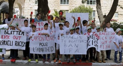 Niños palestinos muestran tarjetas rojas ante el hotel de Blatter en Jerusalén, el pasado día 19.