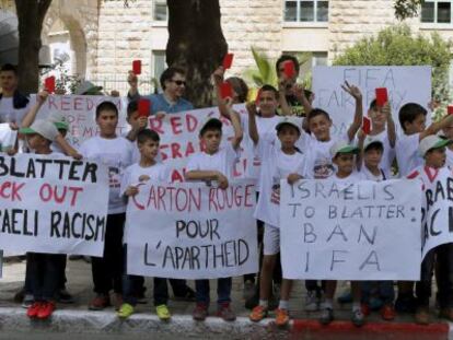 Niños palestinos muestran tarjetas rojas ante el hotel de Blatter en Jerusalén, el pasado día 19.