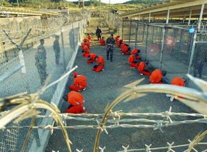 Varios soldados estadounidenses vigilan a presos talibanes y de Al Qaeda en la base de Guantánamo, en enero de 2002.