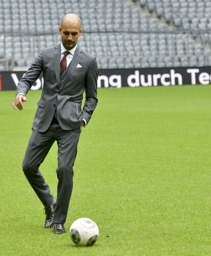 Guardiola golpea un balón sobre el césped del Allianz Arena durante su presentación como entrenador del Bayern.
