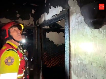 Bomberos en el interior de una vivienda incendiada anoche en la calle Navalcarnero de Alcorcón.