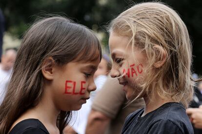 Dos niñas con la cara pintada forman la frase "No él" en brasileño, durante las manifestaciones contra el candidato presidencial de extrema derecha, Jair Bolsonaro, a las elecciones brasileñas, en Río de Janeiro, el 29 de septiembre de 2018.