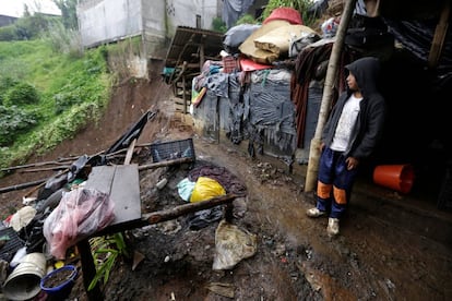 Un niño se resguarda de la lluvia en su vivienda, dañada por un desprendimiento de tierra derivado de la tormenta tropical Earl, en el municipio de Huauchinango, Puebla, en el centro de México.