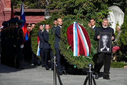 El premio Nobel de la Paz Dmitri Muratov (a la derecha) sostiene una imagen del estadista durante el funeral en el cementerio Novodévichy de Moscú.
