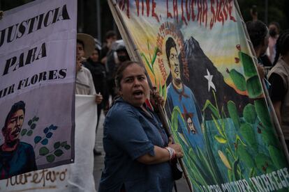 Una mujer grita una consigna durante la marcha. Junto a un acompañante, carga con un cartel que lleva la cara de Samir Flores, campesino y activista mexicano de etnia indígena náhuatl que se opuso a la construcción de una planta termoeléctrica en el Estado de Morelos y que fue asesinado en 2019.