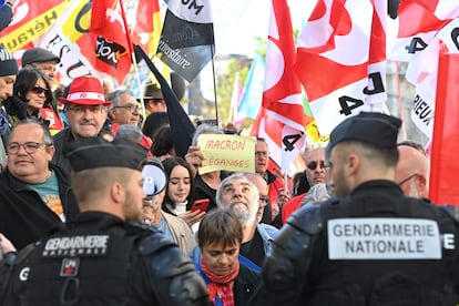 A protester holds a sign that reads, 'Macron Leave',  as they wait for the arrival of the French President a month after his government pushed an unpopular pensions reform act through parliament,  in Ganges, southern France on April 20, 2023. 