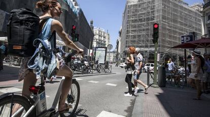 Una mujer con una bicicleta del servicio público de alquiler BiciMad.