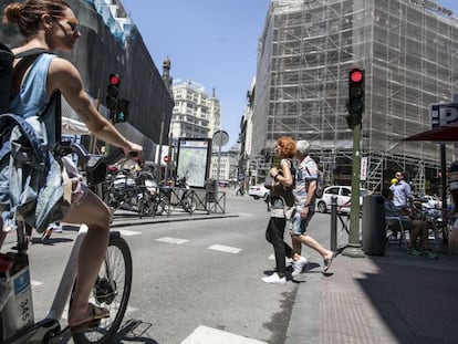 Una mujer con una bicicleta del servicio público de alquiler BiciMad.