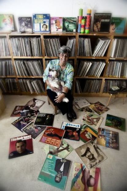 Alejandra Fierro posa con su perro ante algunos de los vinilos que conserva en su casa.