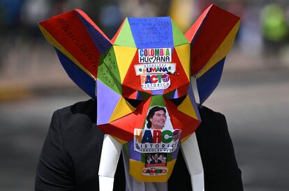 Un manifestante lleva una máscara con consignas contra Nicolás Petro, el hijo del presidente envuelto en un escándalo.