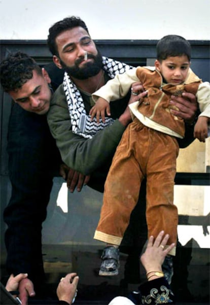 Un prisionero excarcelado coje a un niño en brazos a su llegada a las localidad de Tulkarem. Para algunos es la primera vez que ven a sus hijos fuera de la cárcel. Los liberados se han comprometido mediante una declaración jurada a no volver a usar la violencia.