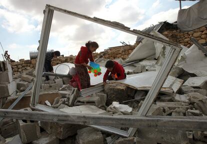 Dos niños palestinos recogen juguetes después de la demolición de sus casas en Jimba al sur de Hebrón (Palestina).