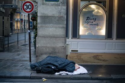 Un hombre sin hogar duerme en una calle en el centro de París.