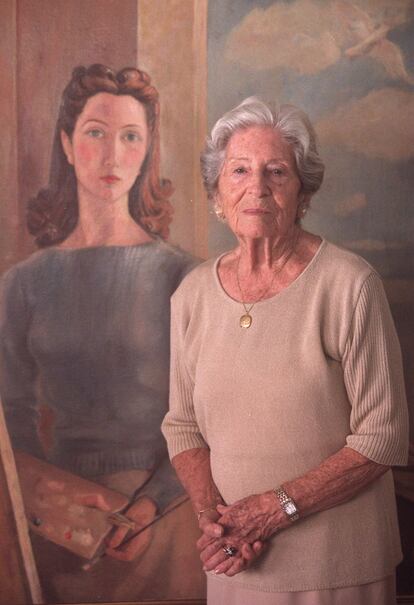 La pintora Ángeles Santos en su casa de Madrid junto a su 'Autorretrato', pintado en 1943