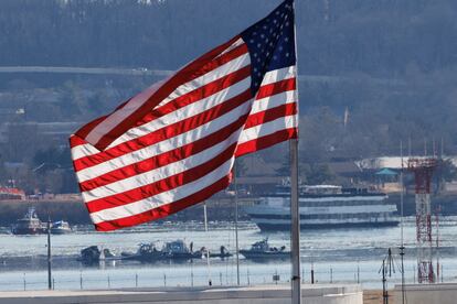 Una bandera estadounidense ondea mientras trabajan los equipos de búsqueda y rescate en el río Potomac, en Arlington, Virginia, al amanecer del 30 de enero de 2025.