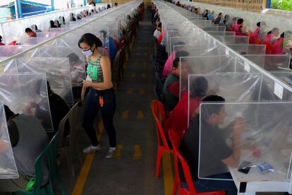 Los trabajadores comen separados por paneles de plástico como medida preventiva contra la propagación del coronavirus, en la planta textil K.P.Textil en San Miguel Petapa, a 20 kilómetros al sur de la ciudad de Guatemala. El país contabilizó 47 muertes por la covid-19 y 961 nuevos contagios en las últimas 24 horas, por lo que suma un total de 1.139 defunciones y 27.619 casos desde que las autoridades detectaran el primer caso el 13 de marzo.