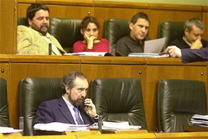 Rafael Larreina, portavoz de EA, durante el debate. Arriba, los parlamentarios de Batasuna.