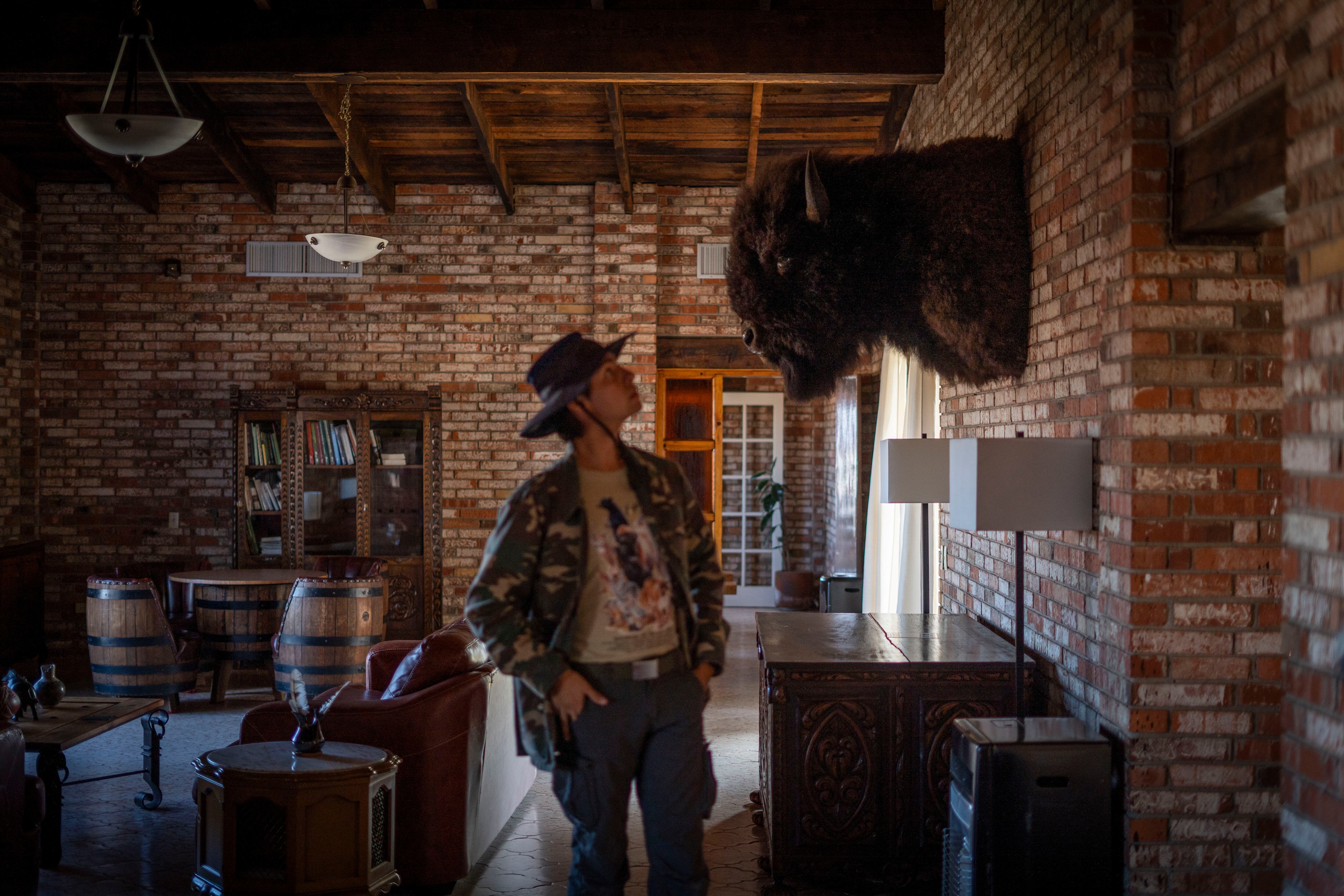 Joaquín García observa la cabeza de un bisonte discado al interior de la casa del Rancho El Uno.