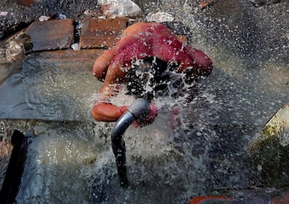 Un hombre se baña en un grifo municipal en Calcuta (India), el 22 de marzo de 2019.