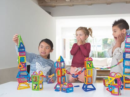 Tres niños juegan a construir.