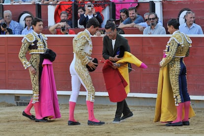 Manuel Caballero, padre, vestido de calle, intercambia los trastos con su hijo en presencia de Paco Ureña, a la derecha, y Roca Rey, a la izquierda.