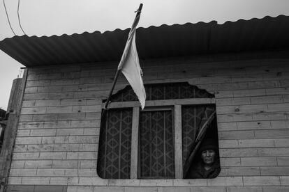 Justina Cigüeñas, de 74 años, se asoma a la ventana en la que ha izado la bandera blanca. Por desesperación muchas familias se han visto obligadas a visibilizar el hambre con este símbolo. En muchos países de América Latina, entre ellos Perú, los que ya no pueden soportar más tiempo en sus casas sin ingresos ni ayudas de ningún tipo están levantando la señal de los rendidos, y en estos casos es el apoyo vecinal lo último que queda.