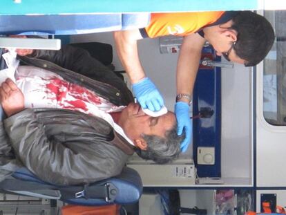 Un sanitario atiende al cochero de Sevilla herido al desbocarse su caballo en el centro de la ciudad y empotrarse contra una sucursal bancaria.