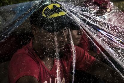 Un joven migrante de honduras se protege de la lluvia bajo un plástico bajo el cual pasara la noche. 

