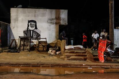 Vecinos de Parcelles Assainies, en Dakar, disfrutan del frescor nocturno tras un día de dificultades asociadas a las lluvias intensas junto a sacos de arena colocados a la entrada de una vivienda para impedir que se inunde de agua. Numerosos cortes de luz asociados a las inundaciones se han vivido en Grand Yoff, Mamelles, Parcelles Assainies, Guediawaye y Pikine, según la empresa de electricidad senegalesa, Senelec.