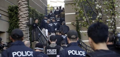 Agentes federales entrando en un complejo de apartamentos de lujo en Irvine, al sur de Los Ángeles, el martes por la mañana.