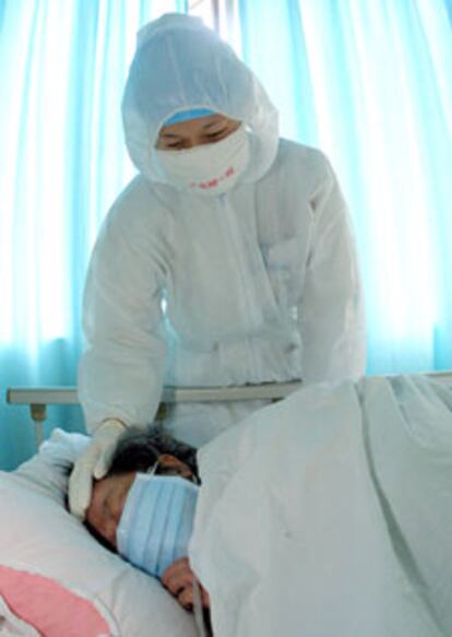 Una enfermera atiende a un paciente de SARS ayer en un hospital de Guangzhou (Guangdong, sur de China).
/ AFP