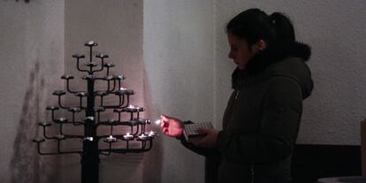 Una jove encén una espelma a l'església protestant de Barcelona en memòria de les víctimes.