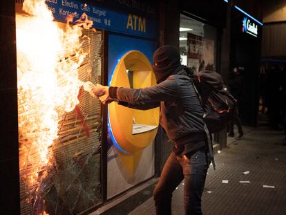 Un encapuchado intenta quemar una sucursal bancaria en Barcelona, el sábado.