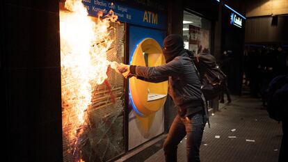 Un manifestante intenta quemar una sucursal bancaria tras las protestas en Barcelona, España, el pasado sábado.