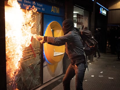 Un manifestante intenta quemar una sucursal bancaria tras las protestas en Barcelona, España, el pasado sábado.