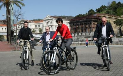 En el centro, Javier Ruiz, candidato del PP a diputado general de Bizkaia, llega en bicicleta a la cita con los medios de comunicación en Bilbao.