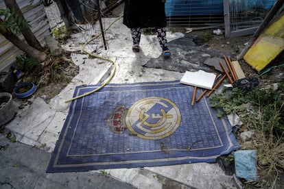 Una alfombra con el escudo del Real Madrid en el acceso a una de las chabolas de la Cañada.