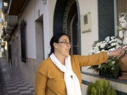 Carmen Muñoz, en la puerta de su casa acaricia la escultura en recuerdo a su hijo Juan Bravo.