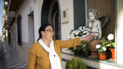 Carmen Muñoz, en la puerta de su casa acaricia la escultura en recuerdo a su hijo Juan Bravo.