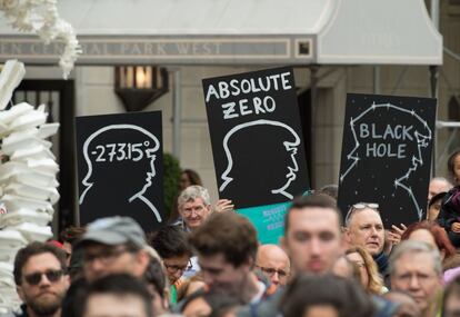 Un grupo de personas se concentra en Nueva York (EE UU) en favor de la ciencia y en contra de los recortes de la Administración Trump. En la imagen, se exhiben tres pancartas con el rostro del presidente de Estados Unidos y con mensajes que critican la actual gestión en materia científica: 'Donald Trump es el cero absoluto (-273.15ºC)' y 'Agujero negro'.