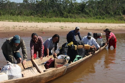 Reyes (segunda por la izquierda), junto a la canoa que se usa para transportar las provisiones y el equipo hasta el poblado.