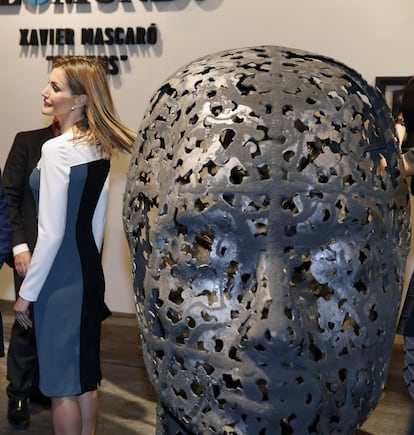 La Reina Letizia, en el stand "Queens", del escultor Xavier Mascaró, junto a una de sus esculturas de rostros de mujeres forjados en hierro.