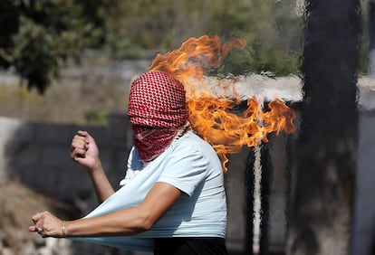 Las llamas devoran el pañuelo que cubre el rostro de un palestino tras lanzar un cóctel molotov contra soldados israelíes durante una protesta en Hebrón (Palestina).