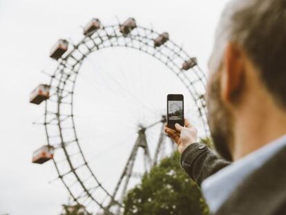 Un hombre toma una fotografía de la noria de Prater.