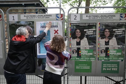 Los voluntarios reemplazan carteles de campaña durante la segunda vuelta de las elecciones parlamentarias francesas en París, Francia.
