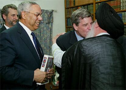 El administrador de EE UU en Irak, Paul Bremer, besa al ayatolá Al Sader en presencia de Colin Powell, ayer en Bagdad.